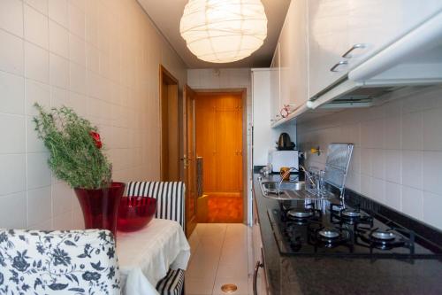 a kitchen with a stove and a table in it at Oporto Central Flat in Porto