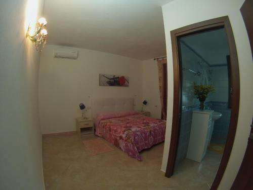 a small bedroom with a bed and a bathroom at La Macchia Mediterranea in Bacu Abis