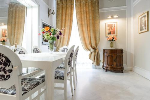 una sala da pranzo bianca con tavolo e sedie bianchi di Edoardo al Plebiscito a Napoli