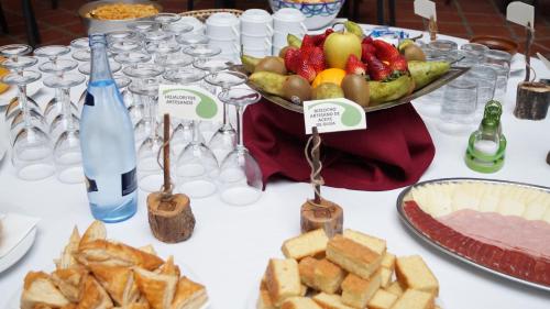 a table with a bowl of fruit and a plate of bread at Caserio de Iznájar in Iznájar