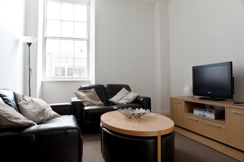 a living room filled with furniture and a tv at My-Canning Street Apartments in Edinburgh