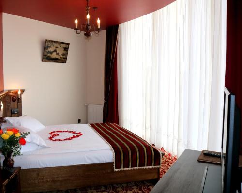 a bedroom with a bed and a large window at Castel Transilvania in Baia Mare