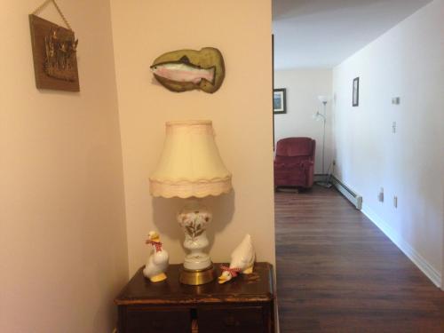 a lamp on a table with a mouth on the wall at Wright's Creek Apartment in Charlottetown