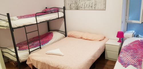 a room with three bunk beds and a small bed at M&F Apartments Sol in Madrid