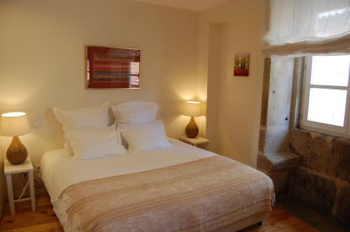 ein Schlafzimmer mit einem Bett mit weißen Kissen und einem Fenster in der Unterkunft Top Flat in Porto