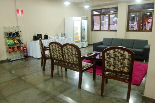 a room with two chairs and a table and a couch at Samba Betim in Betim
