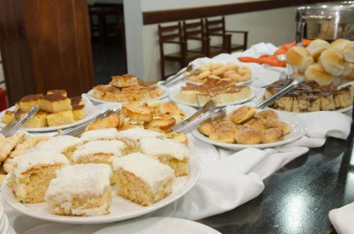 a table topped with plates of cakes and pastries at Samba Betim in Betim