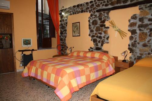 a bedroom with two beds and a stone wall at Casa Cinema Paradiso in Cefalù