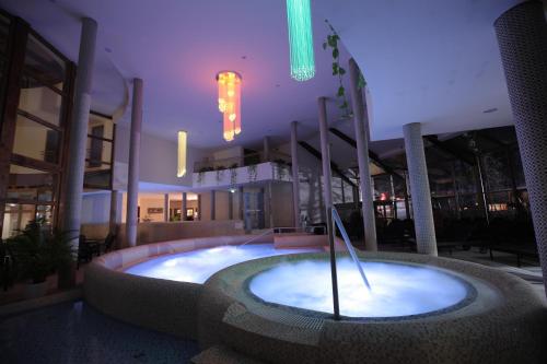 a large building with a hot tub in the middle at Colosseum Hotel in Mórahalom