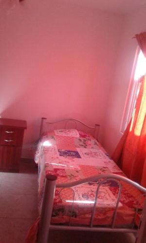 1 dormitorio con 1 cama con pared roja en Mendoza de sol en Villa Nueva