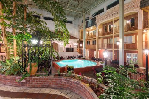 a pool in the middle of a building with plants at Ramada by Wyndham Topeka Downtown Hotel & Convention Center in Topeka