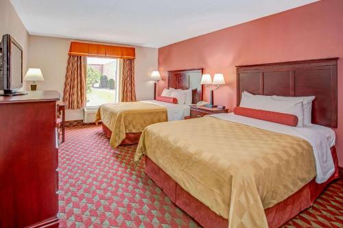 a hotel room with two beds and a television at Ramada by Wyndham Murfreesboro in Murfreesboro