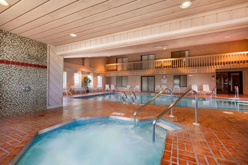 Ramada by Wyndham Wisconsin Dells في ويسكونسن ديلز: مسبح داخلي كبير في غرفة الفندق