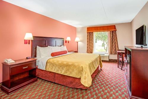 a hotel room with a bed and a television at Ramada by Wyndham Murfreesboro in Murfreesboro