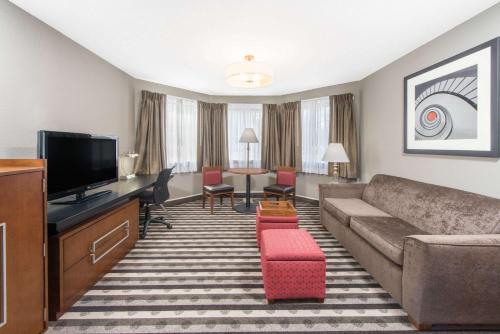 a living room with a couch and a flat screen tv at Ramada by Wyndham Springfield North in Springfield