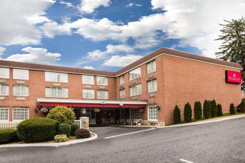 a hotel with a sign on the front of it at Ramada by Wyndham Ligonier in Ligonier