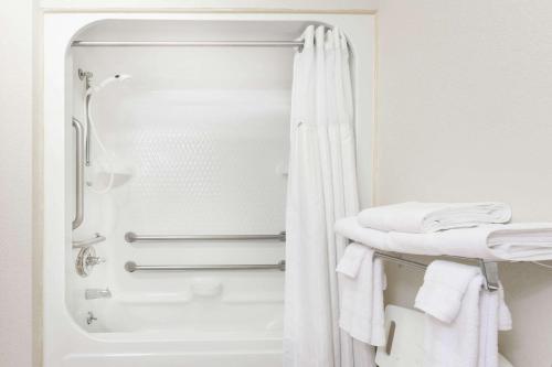 a white bathroom with a shower and a sink at Ramada Worldwide in Tell City