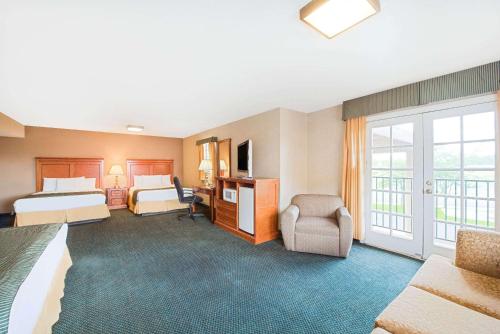 a hotel room with two beds and a balcony at Ramada by Wyndham Flagstaff East in Flagstaff