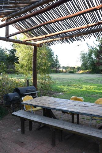 a wooden picnic table and chairs under a pergola at Casa Azul de San Pancho in Paredones