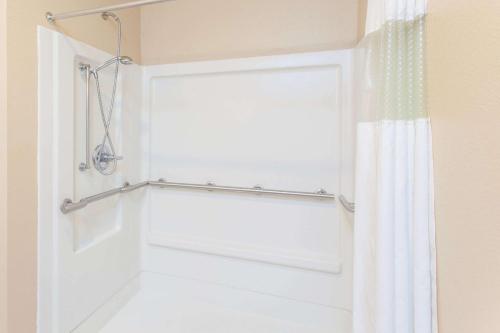 a bathroom with a shower curtain and a door at Ramada by Wyndham Sparta/At Speedway in Sparta