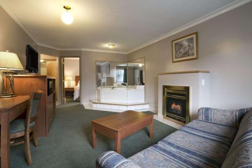 a living room with a couch and a fireplace at Ramada Merritt in Merritt
