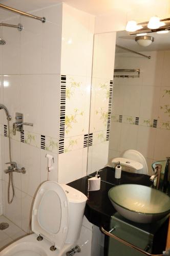 a bathroom with a toilet and a sink at Rajanigandha Family Suites in Dhaka