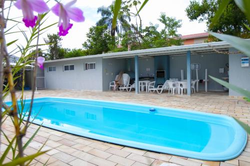 a house with a swimming pool and a patio at Apartamento Erica Itaguá proximo da Praia Grande in Ubatuba