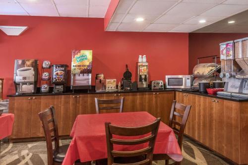 a restaurant with a table with a red wall at Ramada by Wyndham Yonkers - Westchester in Yonkers