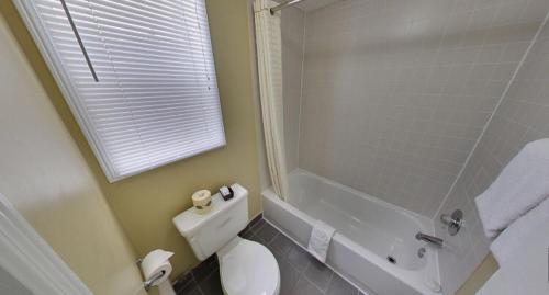 a bathroom with a tub and a toilet and a shower at Budget Inn in Port Hope