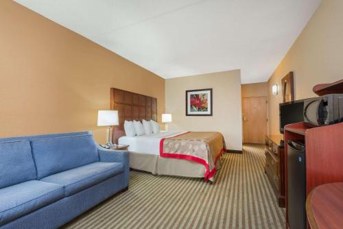a hotel room with a bed and a couch at Ramada by Wyndham Columbus North in Westerville