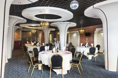a dining room with tables and chairs and ceilings at Ramada Birmingham Oldbury M5 J2 in Oldbury
