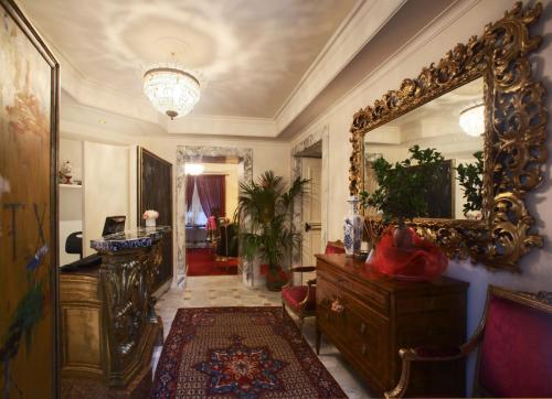 ein Wohnzimmer mit einem Spiegel, einer Kommode und einem Zimmer in der Unterkunft Hotel Villa Duse in Rom