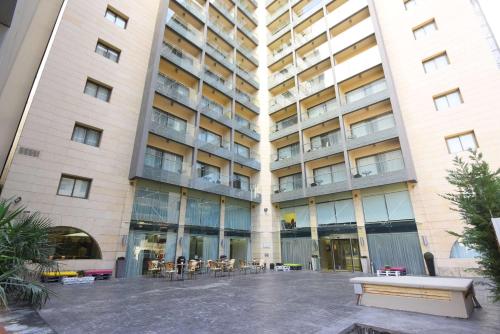 a large building with a bench in front of it at Ramada by Wyndham Downtown Beirut in Beirut