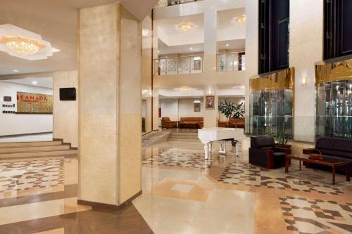 a lobby with a piano in the middle of a building at Ramada Plaza by Wyndham Gence in Ganja