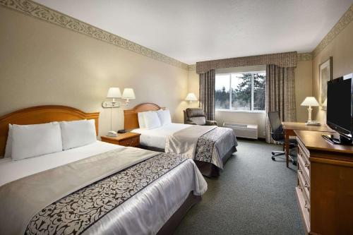 um quarto de hotel com duas camas e uma televisão de ecrã plano em Ramada by Wyndham Olympia em Olympia