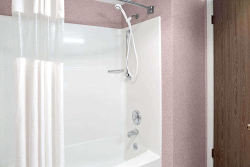 a bathroom with a shower with a shower curtain at Ramada by Wyndham Spokane Valley in Spokane Valley