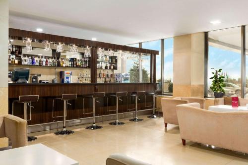 a restaurant with a bar with stools at Ramada Plaza by Wyndham Gence in Ganja