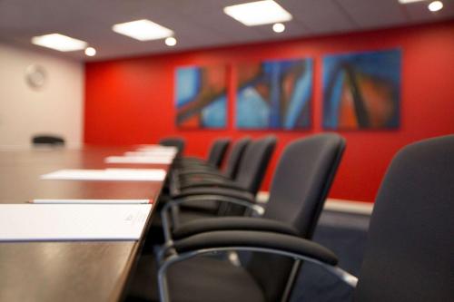 a row of chairs in a conference room with red walls at Ramada Encore Leicester City Centre in Leicester