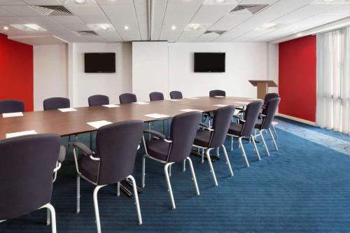 a conference room with a long table and chairs at Ramada Encore Leicester City Centre in Leicester