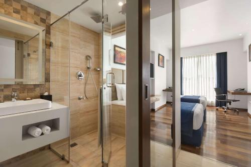 a bathroom with a shower and a sink and a toilet at Ramada Encore Domlur Bangalore in Bengaluru