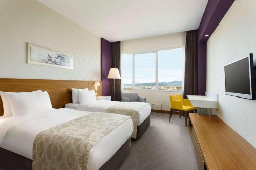a hotel room with two beds and a television at Ramada Plaza by Wyndham Istanbul Asia Airport in Gebze