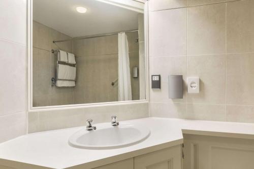 a bathroom with a sink and a mirror at Ramada Crawley-Gatwick in Crawley