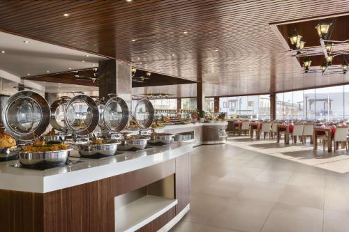 a restaurant with bowls of food on a counter at Ramada Resort by Wyndham Akbuk - All Inclusive in Didim