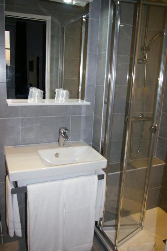 a bathroom with a sink and a shower at Queen Serenity Hotel in Redon