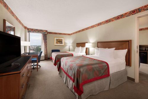 um quarto de hotel com duas camas e uma televisão de ecrã plano em Hotel AVA Laredo em Laredo