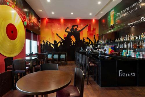a bar with tables and chairs in a restaurant at Ramada Downtown Abu Dhabi in Abu Dhabi