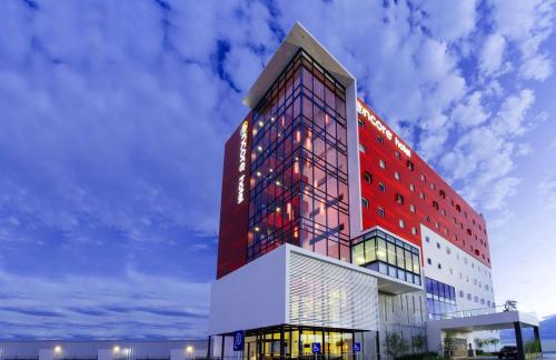 a tall building with red and white at Ramada Encore by Wyndham San Luis Potosi in San Luis Potosí
