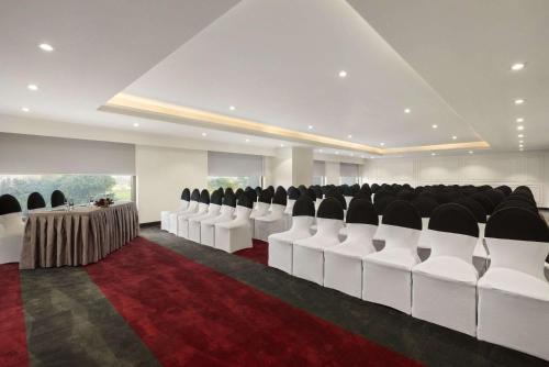 a conference room with white chairs and a red carpet at Saura Hotel, Agra - A Club Mahindra Associate in Agra