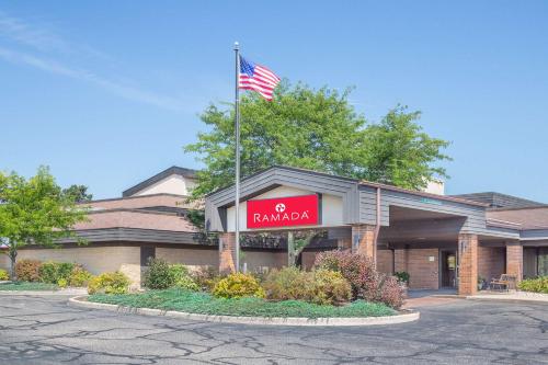 a building with an american flag on top of it at Ramada by Wyndham Waupaca in Waupaca