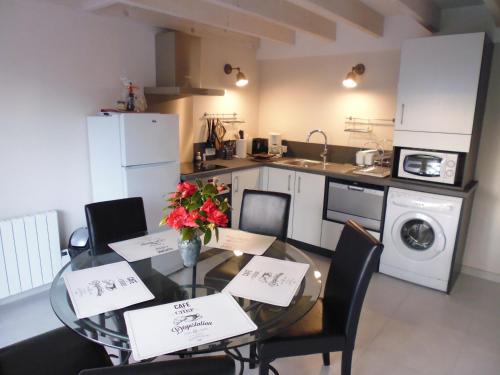 a kitchen with a table and chairs with flowers on it at Gite la Péraie - Le Chêne in Treize-Vents